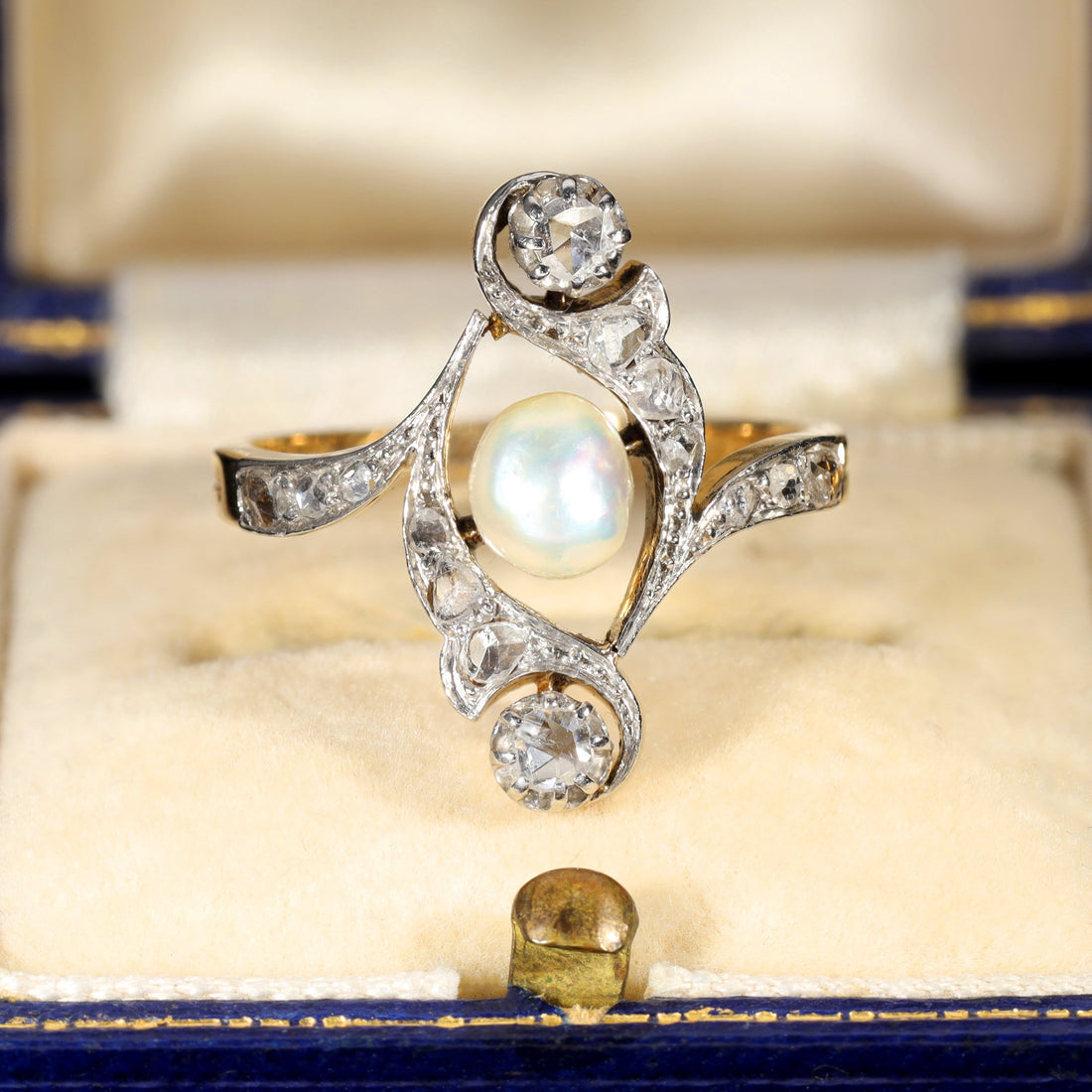 Antique 1917 baroque pearl ring with rose cut diamonds in an elaborate scrollwork mount, the large natural pearl displaying iridescent orient