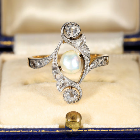 Antique 1917 baroque pearl ring with rose cut diamonds in an elaborate scrollwork mount, the large natural pearl displaying iridescent orient