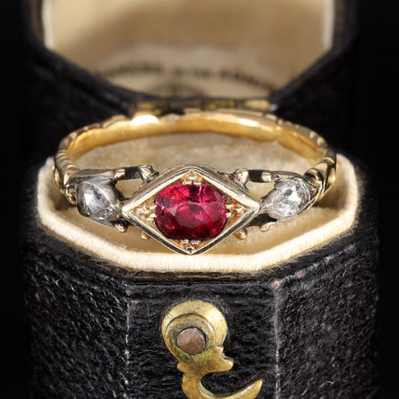 Georgian ruby and rose cut diamond ring in gold with a central ruby set in a diamond-shaped collet flanked by rose cut diamonds