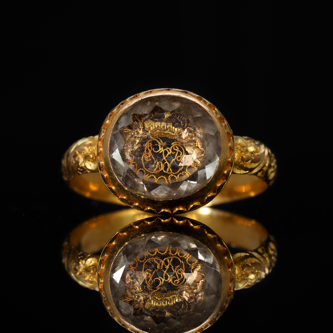 Seventeenth-century gold mourning ring with faceted rock crystal bezel covering a gold wire monogram and crown motif, a style associated with Stuart-era political loyalty