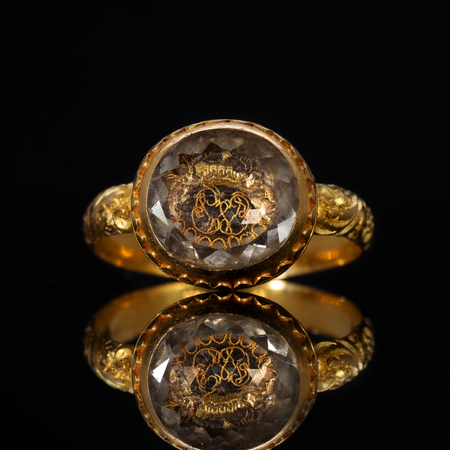Seventeenth-century gold mourning ring with faceted rock crystal bezel covering a gold wire monogram and crown motif, a style associated with Stuart-era political loyalty