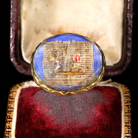 17th century Stuart crystal ring in gold with faceted rock crystal over a cherub and vase scene set on woven hairwork with blue enamel background
