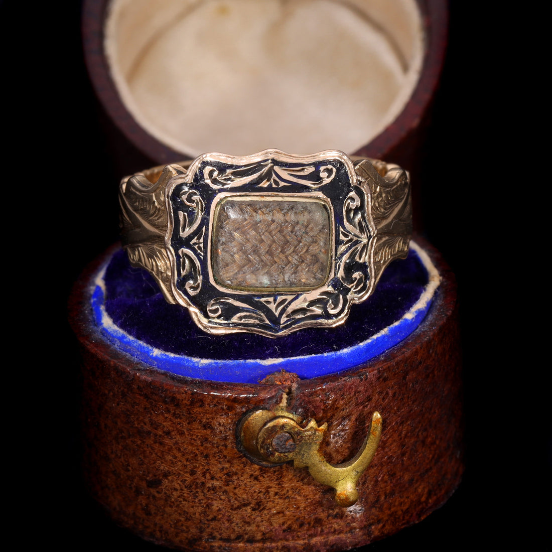Victorian 9ct gold mourning ring from 1864 with woven hairwork panel under glass and black enamel scrollwork