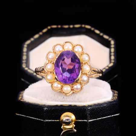 Vintage amethyst and pearl cluster ring with oval faceted amethyst surrounded by seed pearls in a gold setting