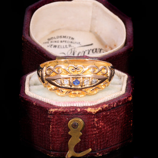 Edwardian sapphire and diamond five-stone scrollwork ring in 18ct gold, circa 1909, presented in its original jeweller's box