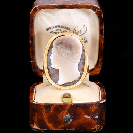 17th century hardstone cameo ring with white agate portrait of a young man in profile against a dark ground, set in a plain gold bezel mount, displayed in an original antique jeweller's box