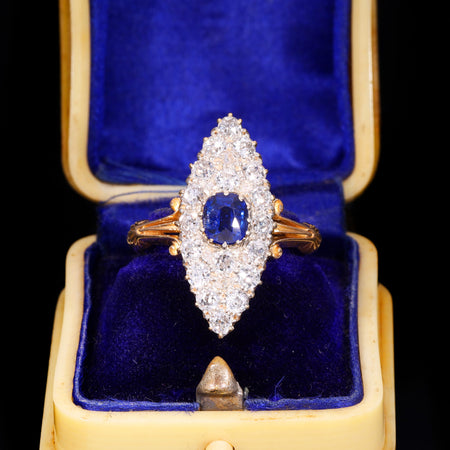 Victorian sapphire and old cut diamond navette ring in yellow gold, with a central oval blue sapphire surrounded by old cut diamonds in a marquise-shaped cluster setting