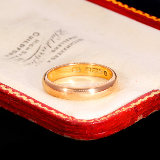 Victorian 22ct yellow gold wedding ring from 1853 with a full set of hallmarks visible inside the band, displayed on an antique jeweller's box with red leather and cream silk lining