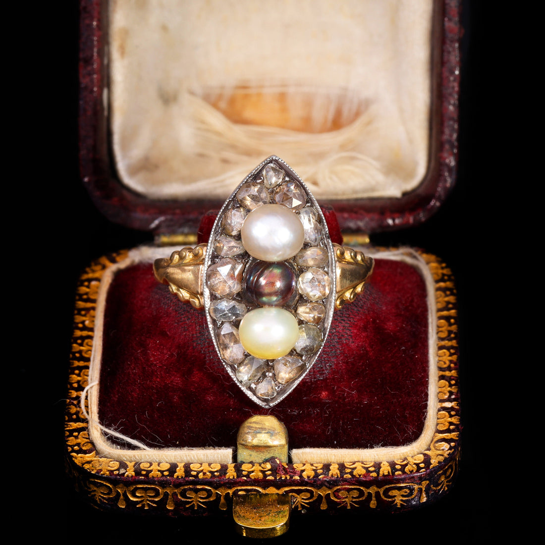 Georgian navette ring with three natural pearls surrounded by rose cut diamonds in a marquise-shaped bezel with gold and silver mounting, displayed in an original antique ring box