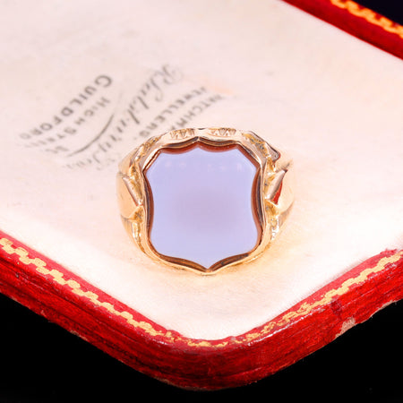 Victorian 15ct gold signet ring dated 1881, set with a blue agate shield in a decorative gold mount, showing the warm yellow colour characteristic of 15ct gold