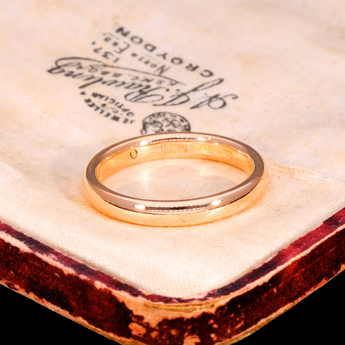 Victorian 22ct yellow gold wedding band from 1861, narrow D-profile with warm patina, displayed on antique jeweller's paper