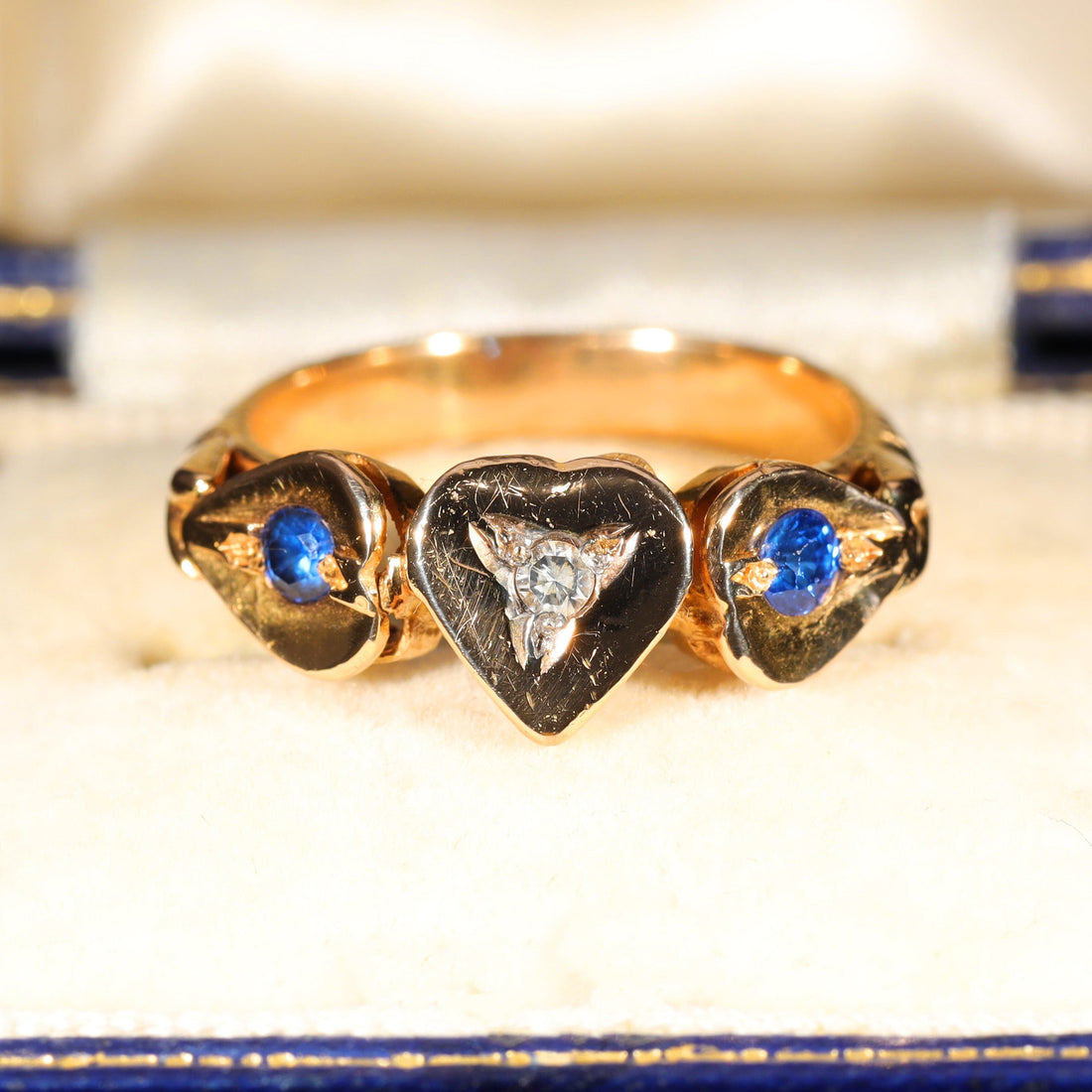 Edwardian triple heart ring in gold with central diamond and flanking sapphires