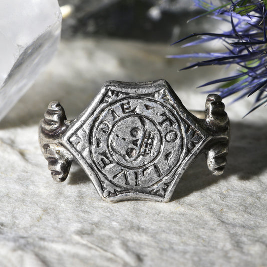 Post-medieval memento mori skull ring in silver with engraved skull and crossbones on hexagonal bezel, inscribed 'Die To Live', circa 1500-1650