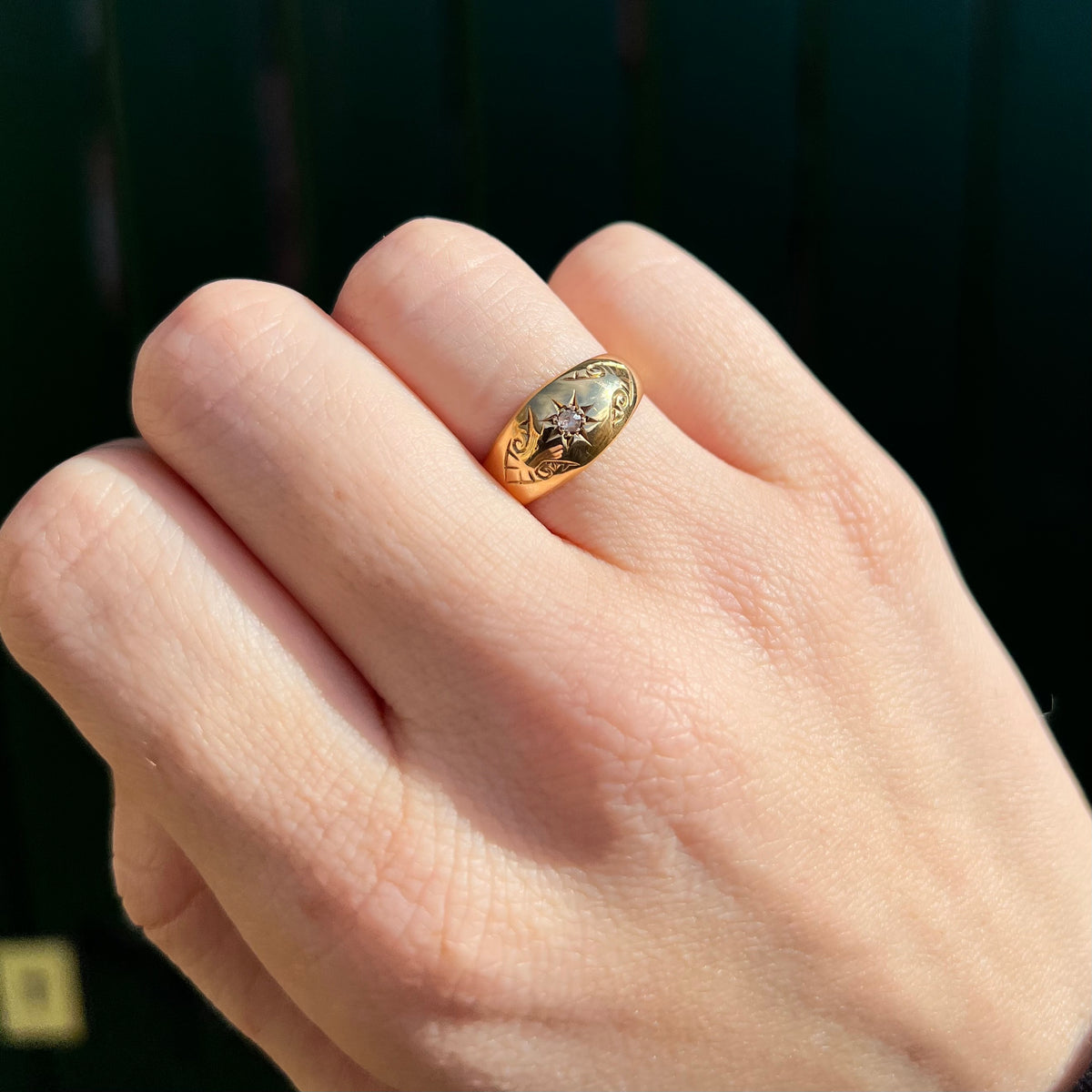 Ring worn on hand showing scale and star-set diamond on domed oval face