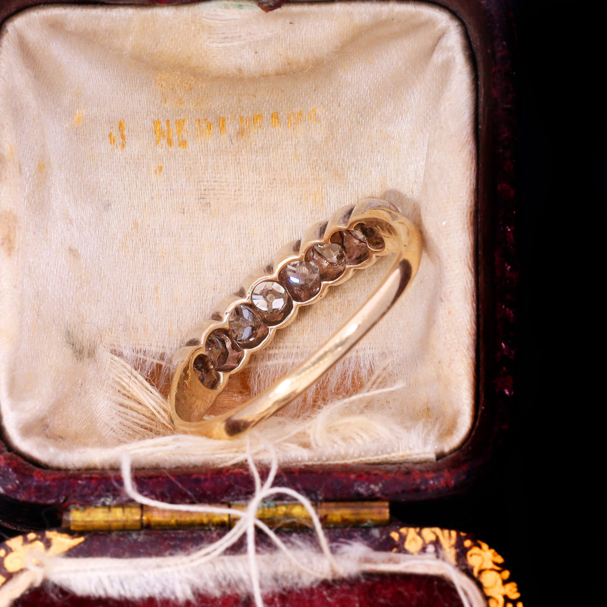 Top view of eight graduated old mine-cut diamonds in silver grain-and-claw settings