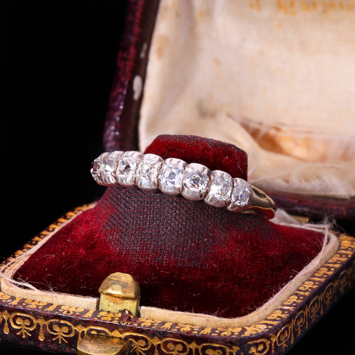 Front view of eight graduated old mine-cut diamonds in silver grain-and-claw settings