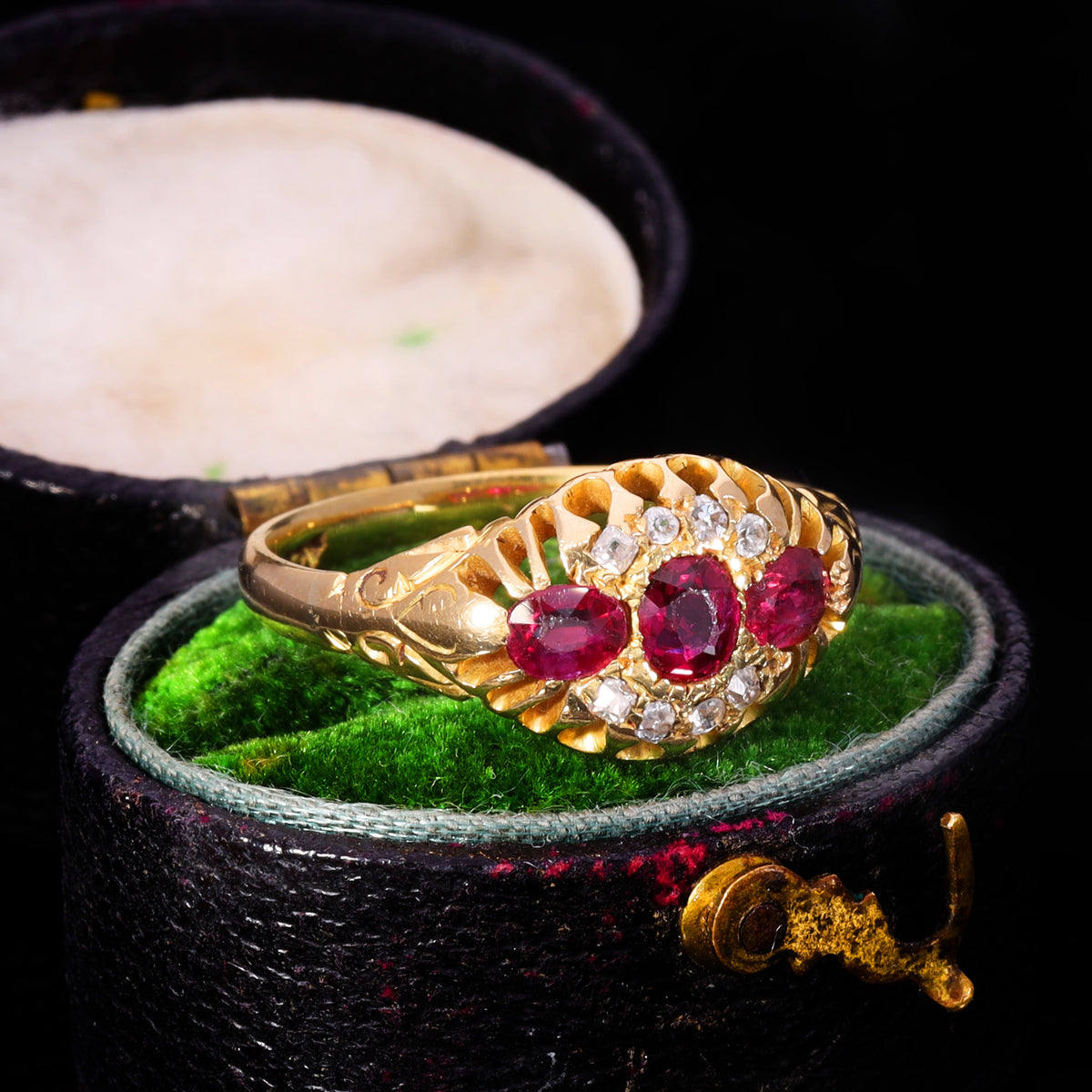 Three-quarter view of Victorian three-stone ruby and old cut diamond cluster ring