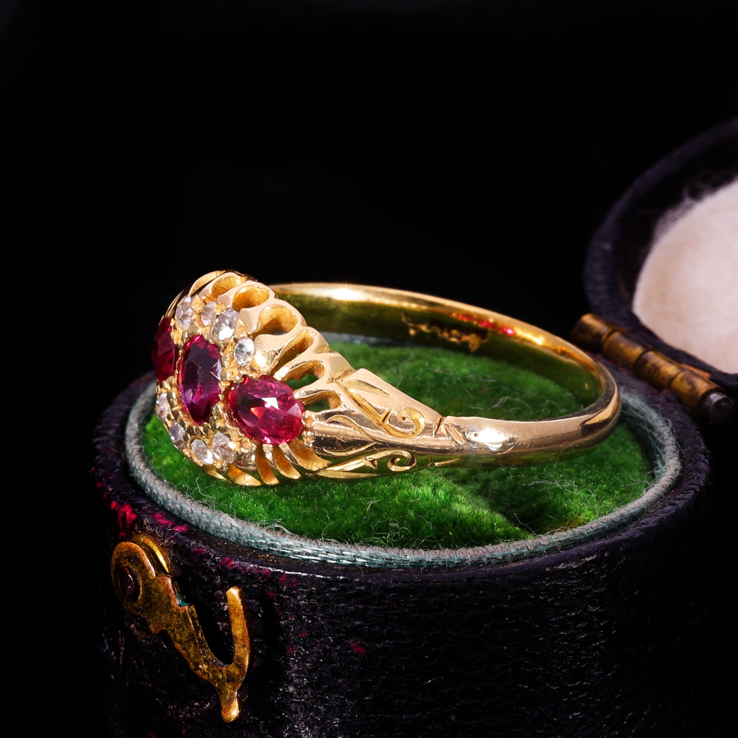 Side profile showing openwork claw setting and scrollwork shoulders in 18ct gold