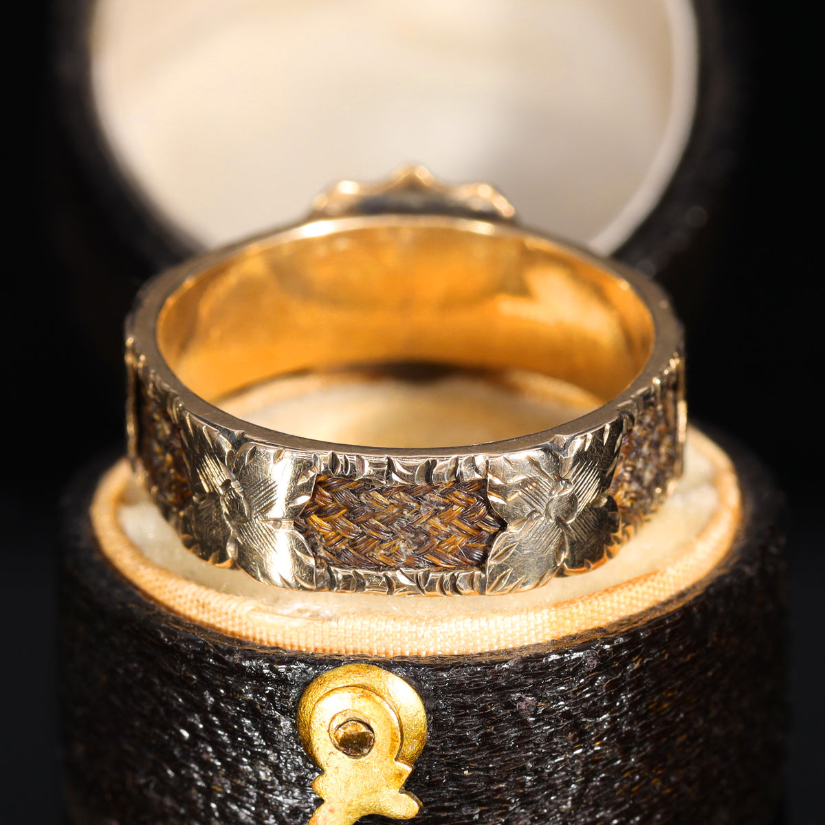 Back view of braided hairwork panel with engraved floral gold surround