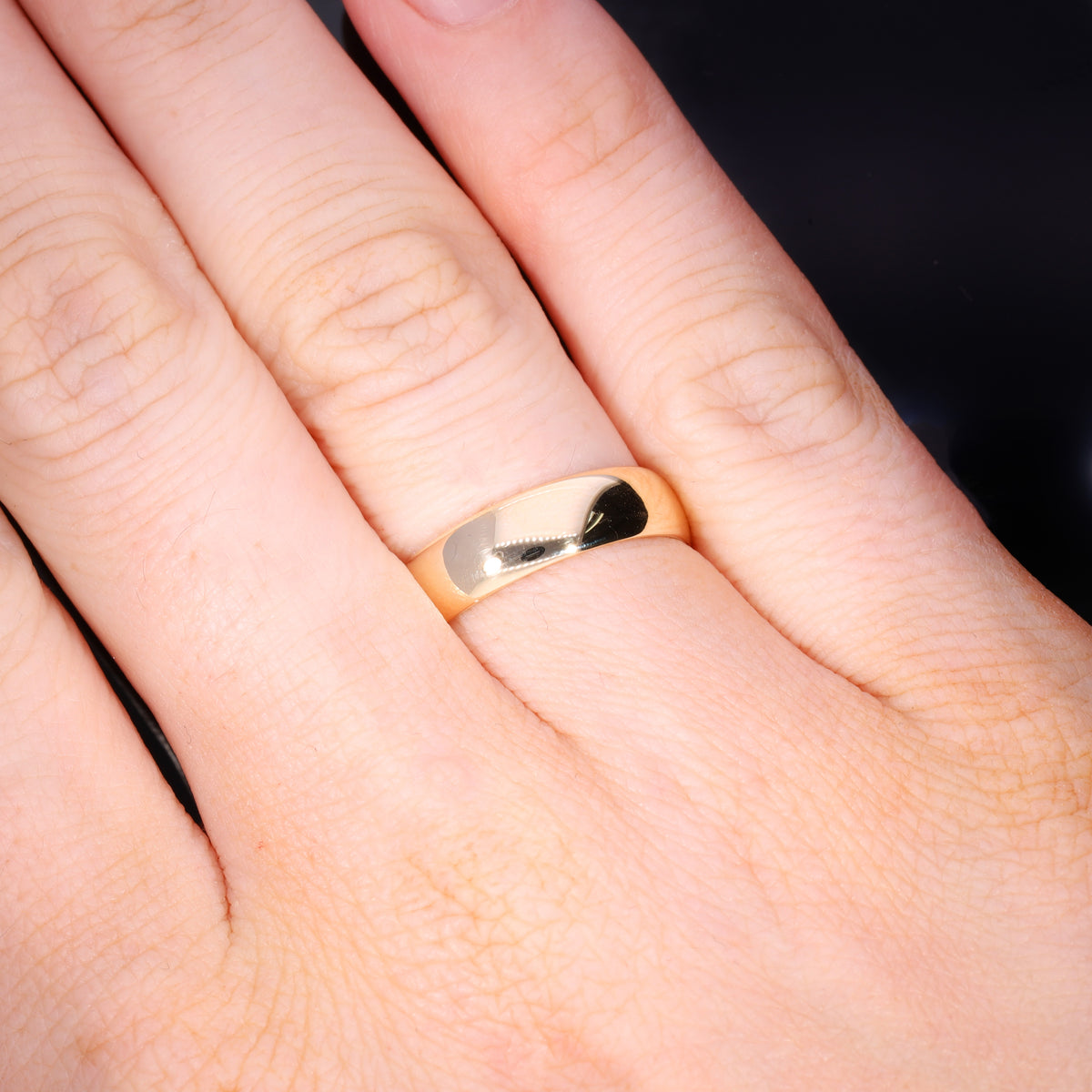 Ring worn on hand showing scale and width of plain gold band