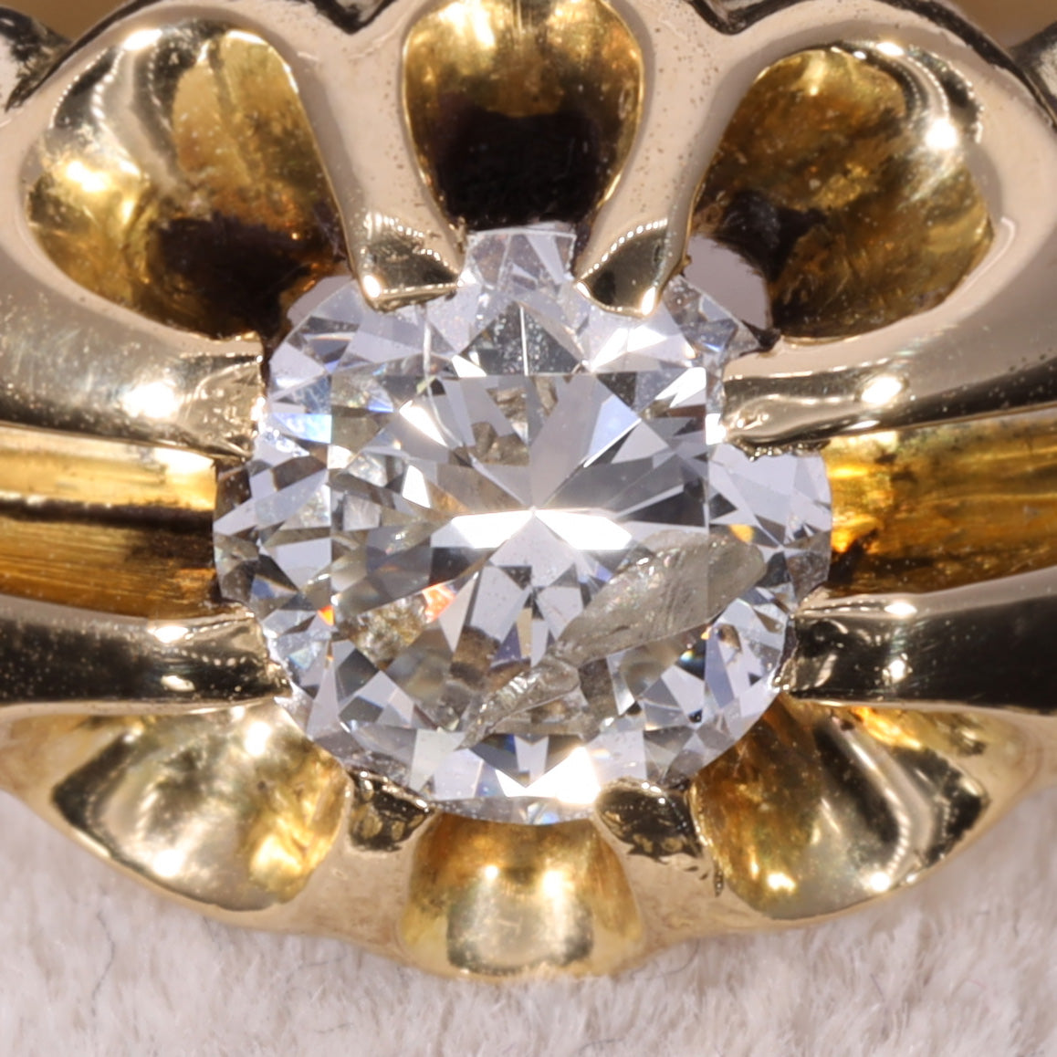 Close-up of brilliant-cut diamond in 18ct gold belcher buttercup setting