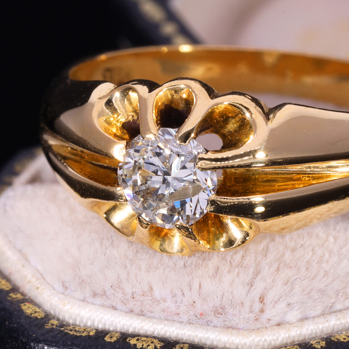 Close-up of brilliant-cut diamond in 18ct gold buttercup belcher setting