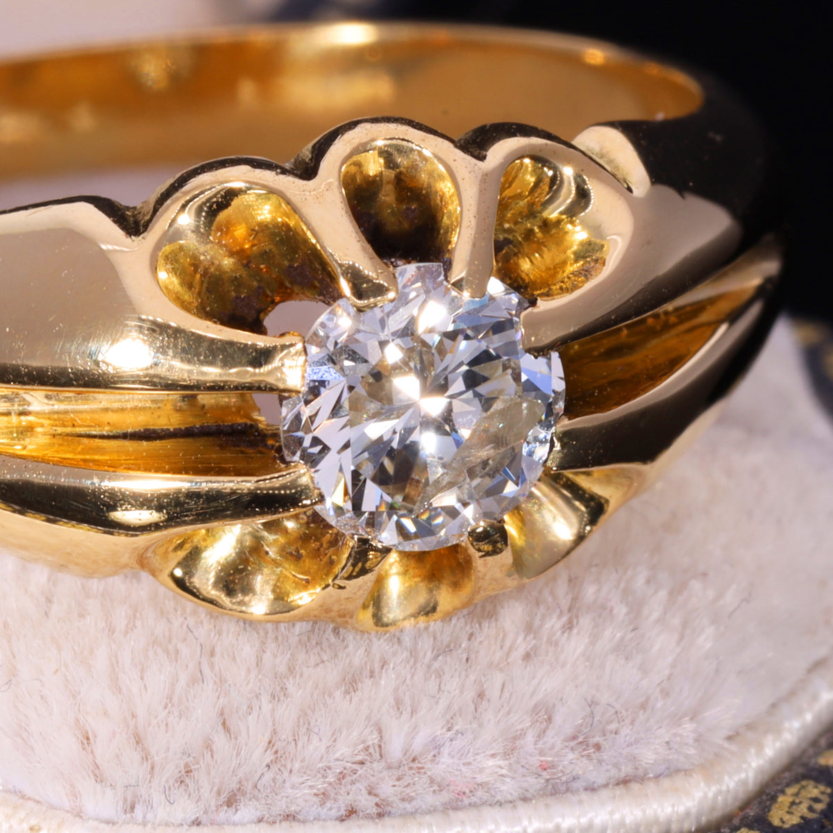 Close-up of brilliant-cut diamond in 18ct gold belcher buttercup setting