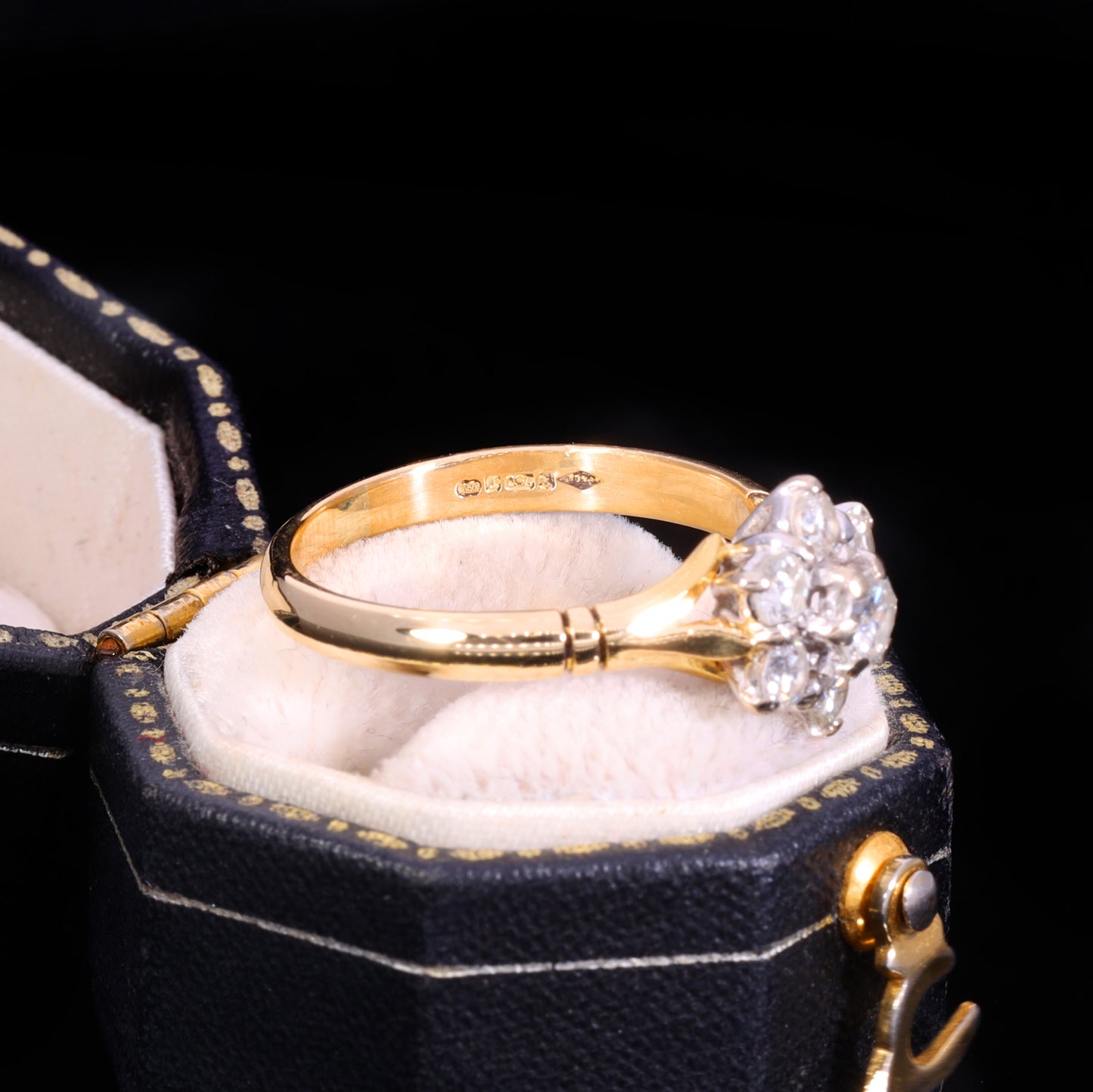 Side profile of 18ct gold diamond cluster ring showing hallmarks on inner band