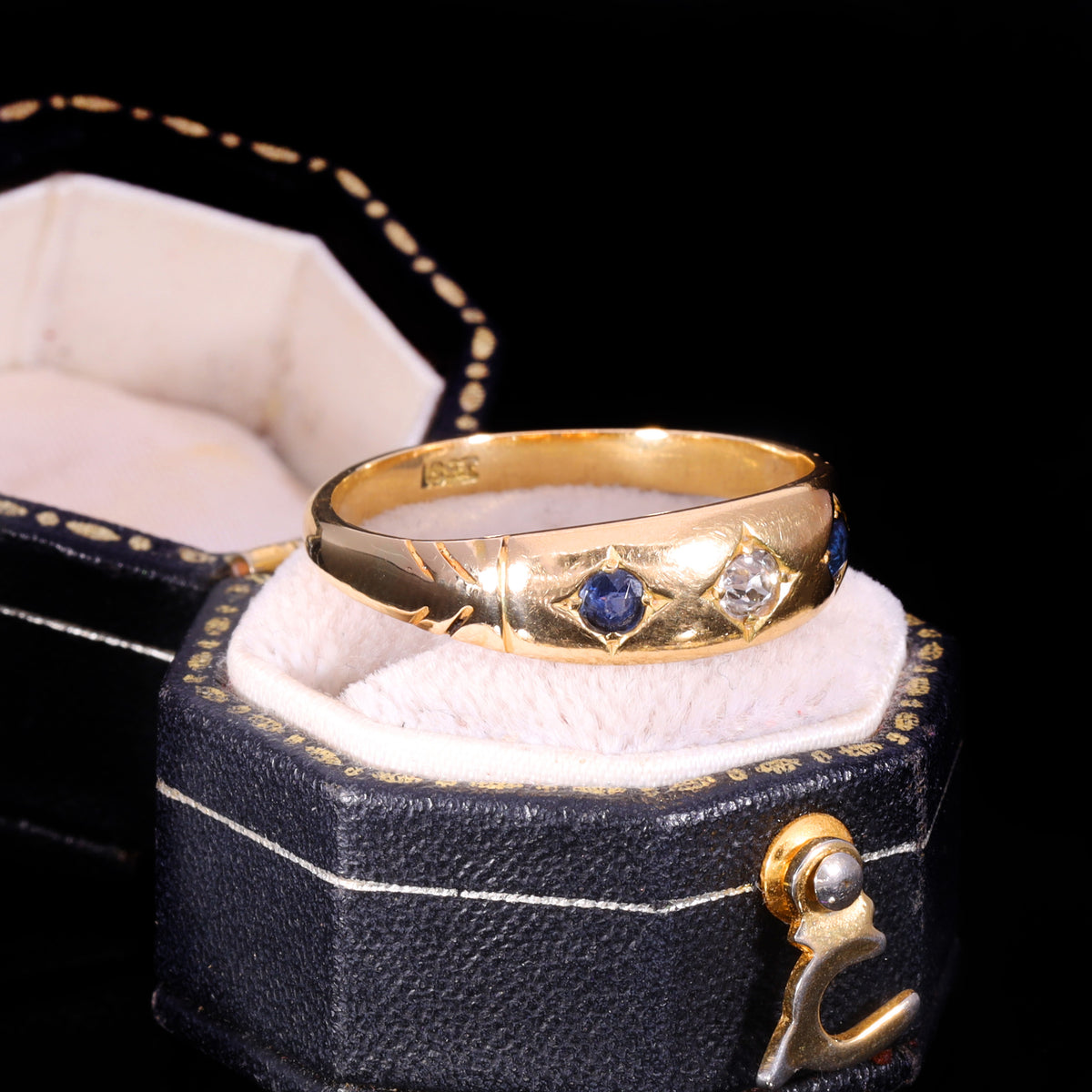 Three-stone gypsy ring with sapphires and old-cut diamond in star settings