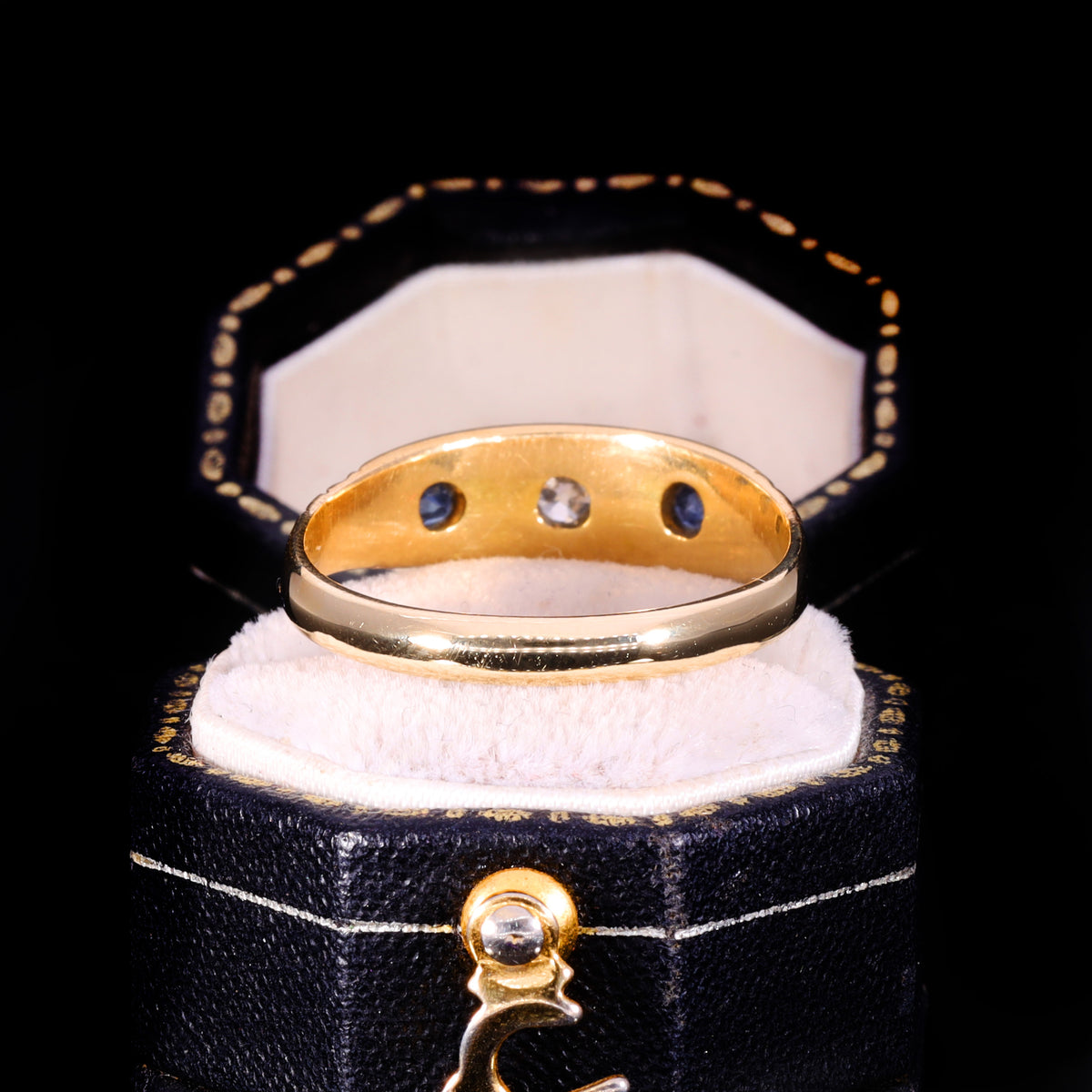 Interior view showing gypsy-set diamond and sapphire trio in 18ct gold band