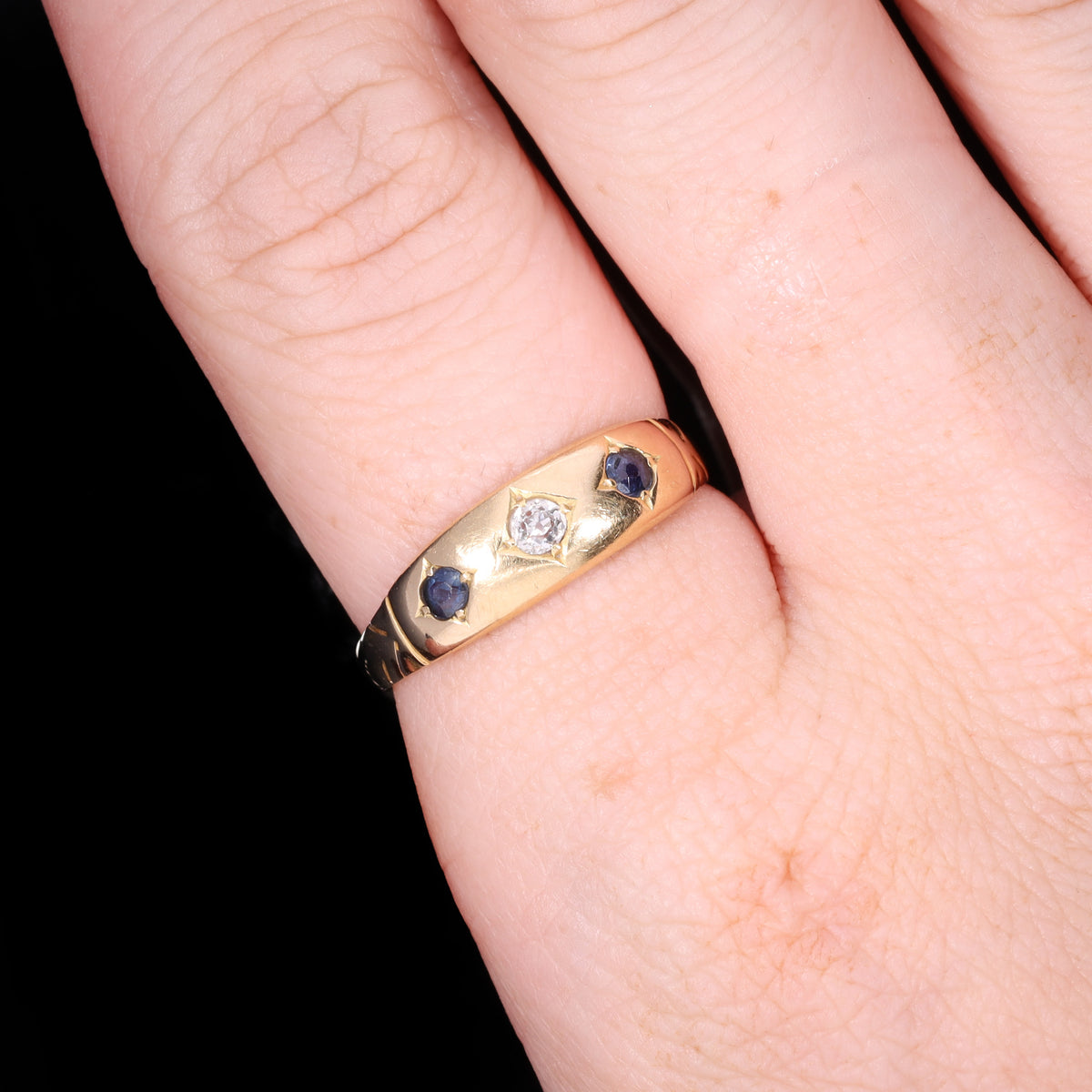 Ring worn on hand showing scale, Victorian gold gypsy band with sapphires and diamond
