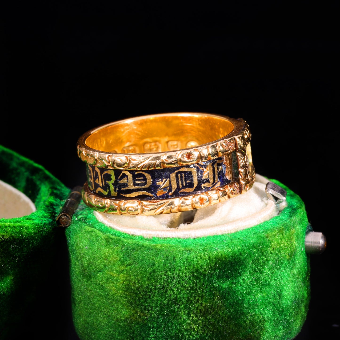 Three-quarter view of Victorian gold mourning ring with blue enamel and Gothic lettering