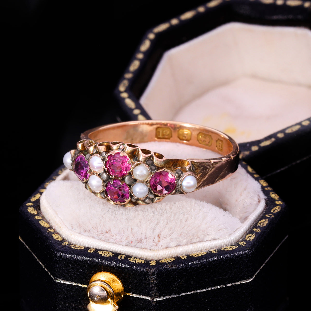 Three-quarter view of Victorian almandine garnet and seed pearl cluster ring