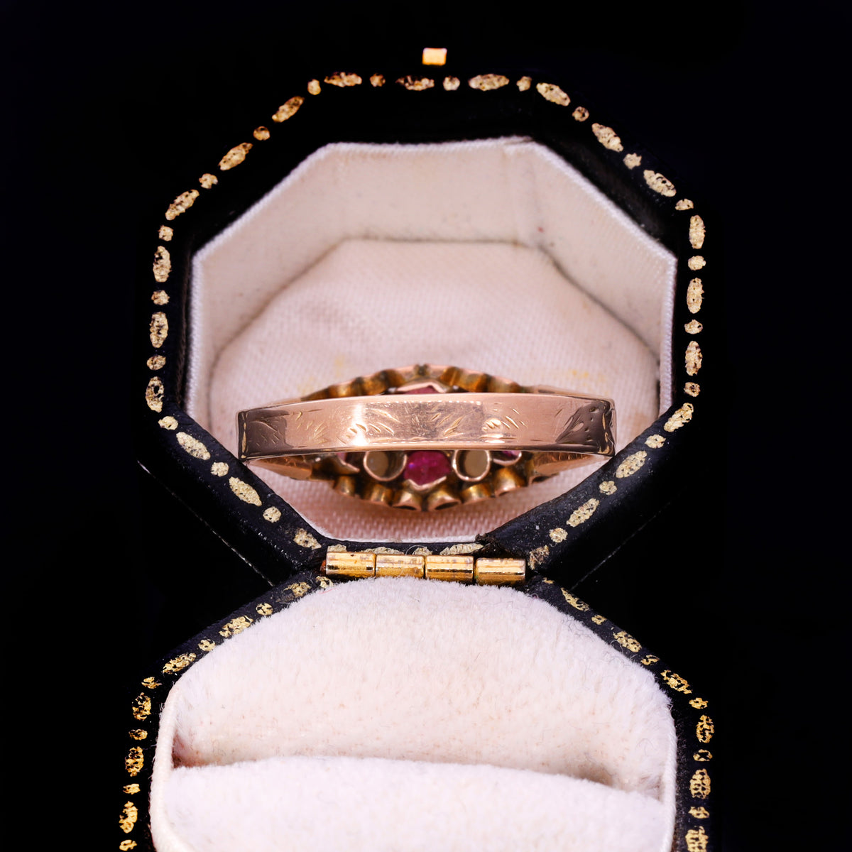 Side profile showing engraved band and garnet cluster in ornate navette setting