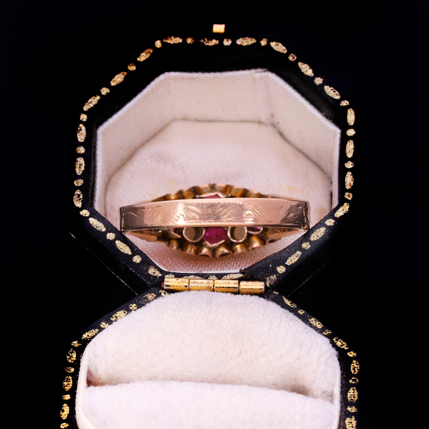 Side profile showing engraved band and garnet cluster in ornate navette setting
