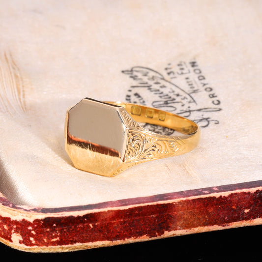 Three-quarter view of Victorian 18ct gold signet ring with engraved foliate shoulders